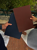 navy blue and brown leather MacBook sleeves held together, lifestyle